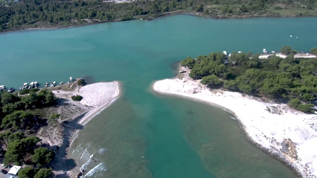 鸟瞰图田园般的海滩与天然海港和树木，格拉卡沃斯，哈尔基迪基希腊，由无人机向后移动视频素材