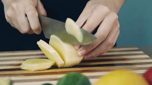 在砧板上切土豆。关闭了。环的土豆。切些蔬菜做沙拉。健康食品。视频素材