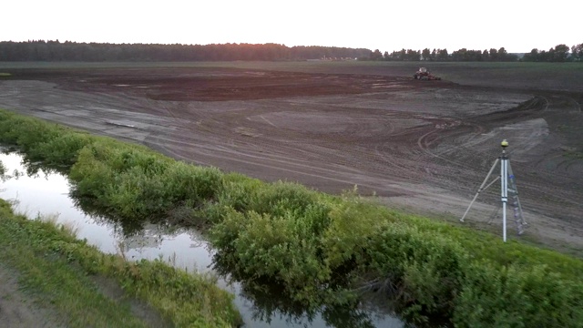 用经纬仪和拖拉机在田野上进行空中运动视频素材