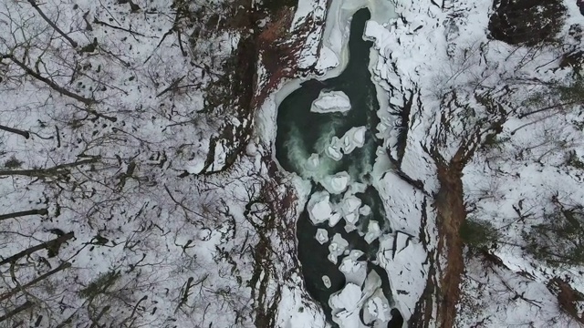 第一场雪就在山涧与河流之间。顶尖的鸟瞰图视频素材