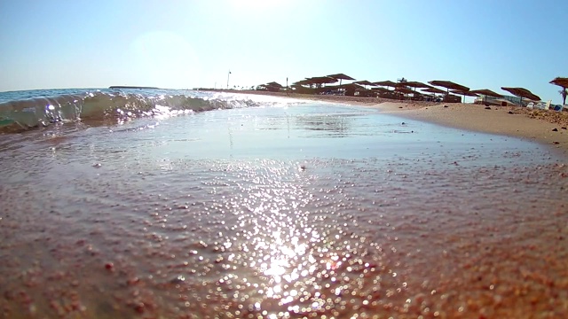 在晴朗的日子里，海浪在沙滩上冲浪，红海，从岸边俯瞰，超宽的圆角。慢动作标准动作。视频下载