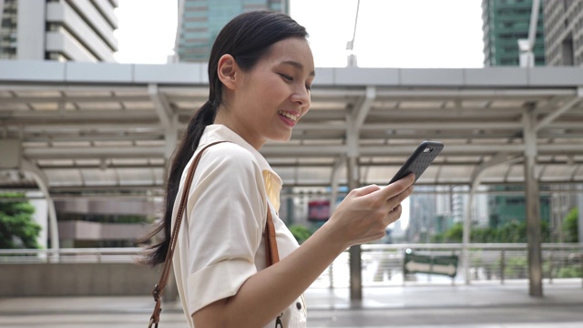 亚洲女性在城市使用智能手机视频素材