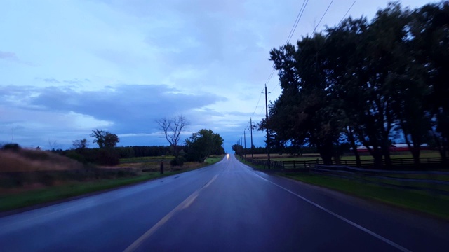 在阴天下驾驶乡村潮湿的道路。司机的观点POV后，黑暗的暴雨与水的街道。视频素材