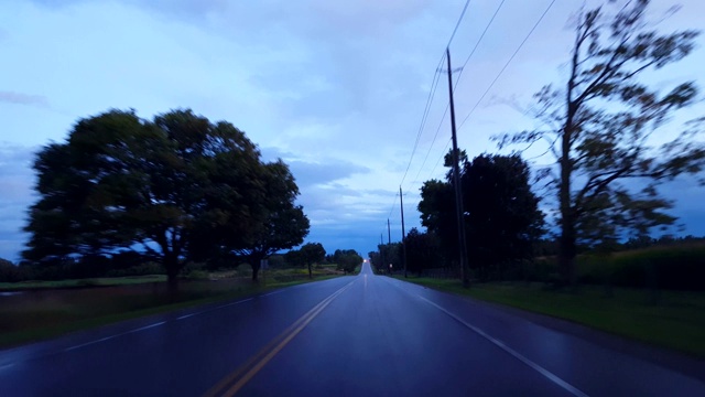 在阴天下驾驶乡村潮湿的道路。司机的观点POV后，黑暗的暴雨与水的街道。视频素材