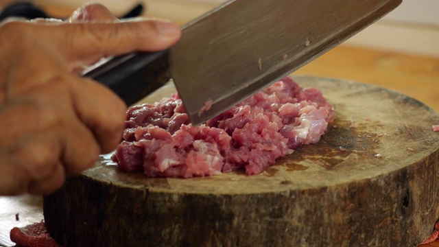 自制的食物。用慢动作在木砧板上切生猪肉视频素材