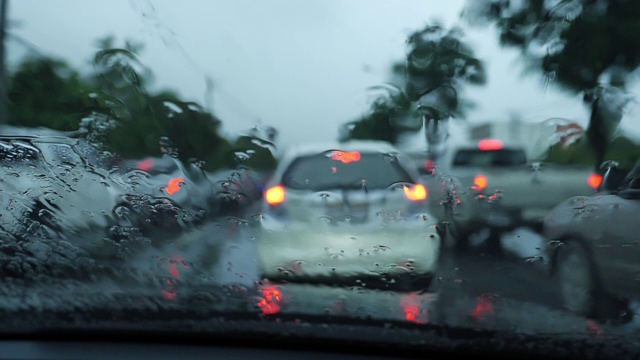 慢镜头，雨点与交通堵塞一起落在挡风玻璃上视频素材