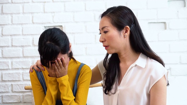 亚洲母亲安慰哭泣的十几岁的女儿在痛苦，压力，沮丧，悲伤的心态视频素材