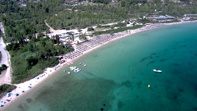 鸟瞰图在Pefkohori Halkidiki，希腊，长期田园诗般的绿松石水海滩，由无人机向前和向下移动视频素材