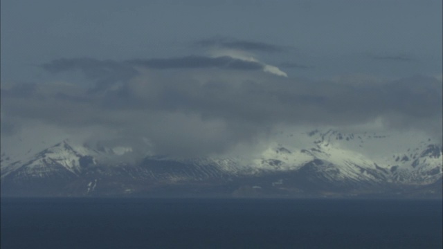 低低的云层飘过雪白的海岸山脉。视频素材