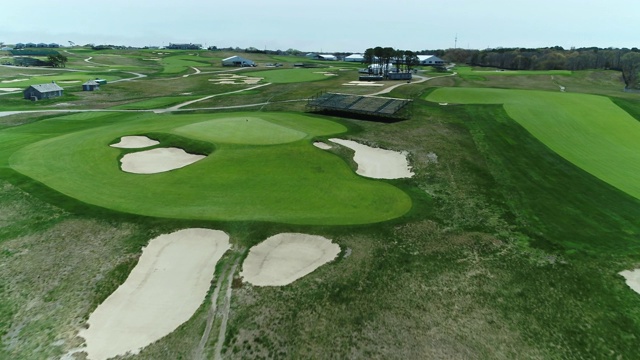 4K无人机飞向洞和旋转在美丽的高尔夫球场上的绿色视频素材