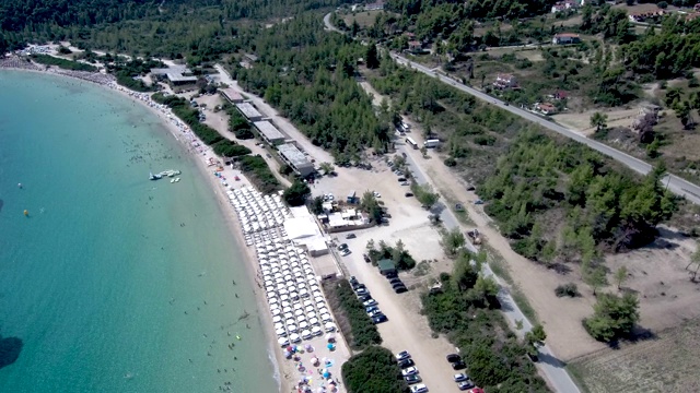 鸟瞰图在Pefkohori Halkidiki，希腊，长期田园诗般的绿松石水海滩，由无人机向前移动视频素材