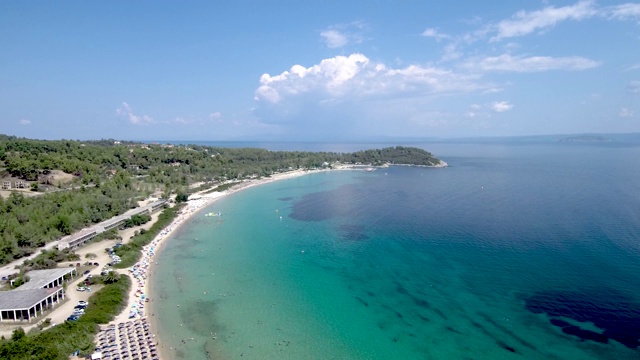 鸟瞰图在Pefkohori Halkidiki，希腊，长期田园诗般的绿松石水海滩，由无人机向前移动视频素材