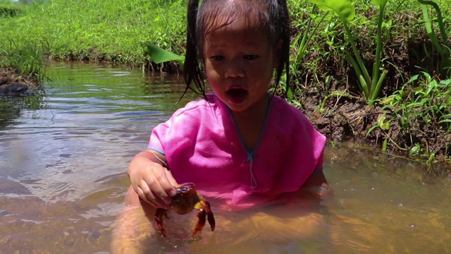 孩子们赤脚在溪水中玩耍，玩泥巴和沙子。视频素材