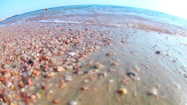 在晴朗的日子里，海浪在沙滩上冲浪，红海，从岸边俯瞰，超宽的圆角。慢动作标准动作。视频素材