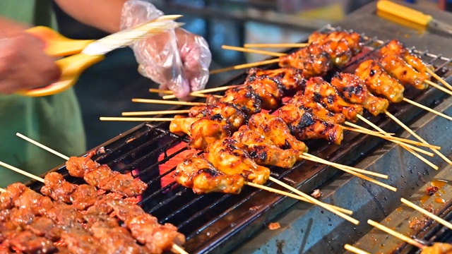 近距离的手翻肉在烧烤的街头食品，泰国视频素材