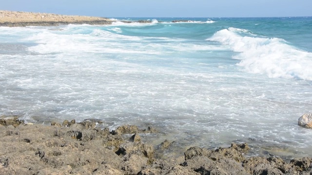 波浪在岩石的海岸上翻滚视频下载