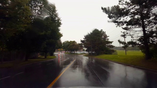 夏日阴天下的雨城街道。司机视角:雨刷雨刷下的城市湿路。视频素材