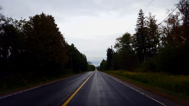 在阴天下驾驶乡村潮湿的道路。司机的观点POV后，黑暗的暴雨与水的街道。视频素材