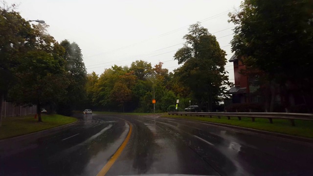 夏日阴天下的雨城街道。司机视角:雨刷雨刷下的城市湿路。视频素材