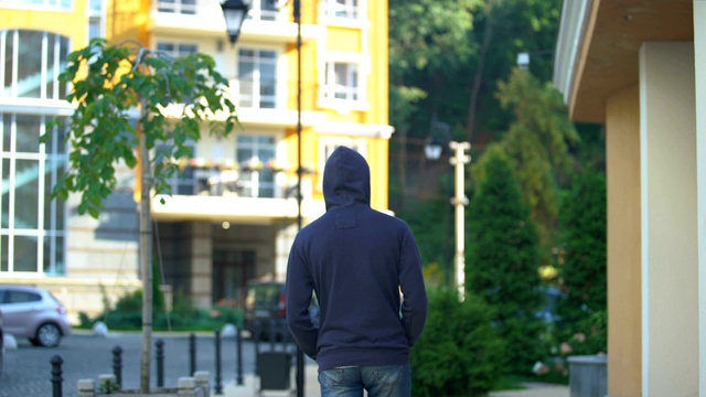 戴着头巾的悲伤男子慢慢地走在街上思考着未来，问题视频素材