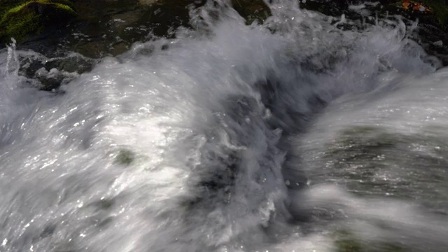 崎岖的山涧里流淌着晶莹剔透的飞溅水视频素材