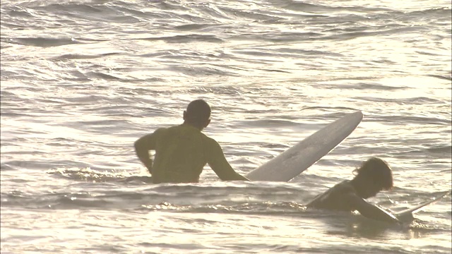 在夏威夷毛伊岛，汹涌的海浪冲刷着冲浪者。视频素材