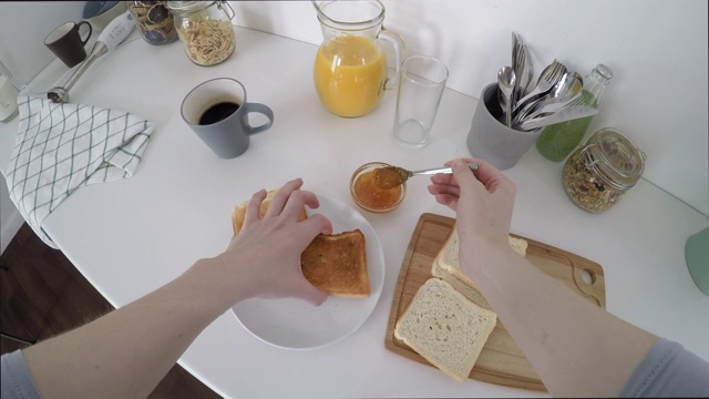 女人做果酱吐司和早餐倒果汁的视频视频素材