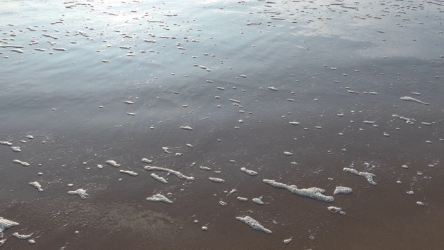 海浪在沙滩上形成白色的泡沫视频素材