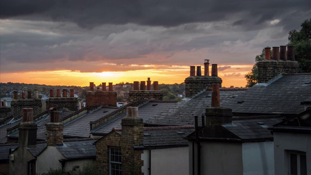 俯瞰着烟囱和住宅的石板屋顶，夕阳穿过伦敦南部低沉的乌云视频素材