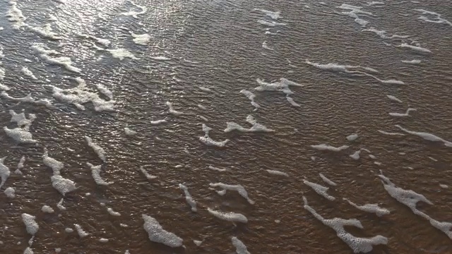 海浪在沙滩上形成白色的泡沫视频素材