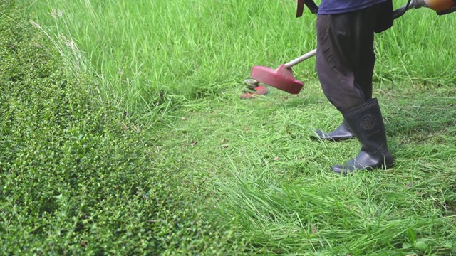 园丁正在花园里使用割草机。视频素材