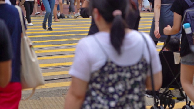 一群人走过斑马线或人行横道的慢动作。商业交通道路在繁忙的城市。香港市区。视频素材