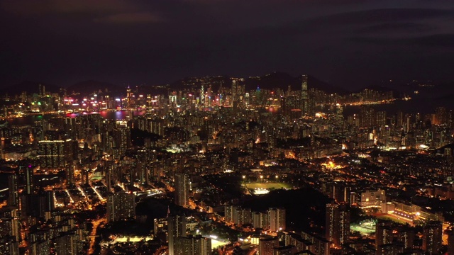 无人机夜间鸟瞰香港城市景观。紧密的空中向前射击飞过办公大楼和摩天大楼。视频素材