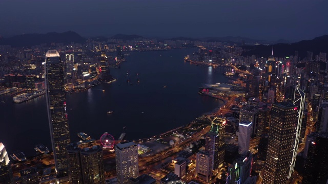 无人机夜间鸟瞰香港城市景观。紧密的空中向前射击飞过办公大楼和摩天大楼。视频素材