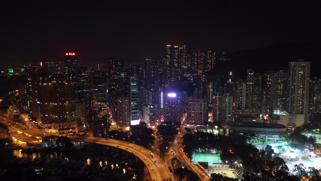 无人机夜间鸟瞰香港城市景观。紧密的空中向前射击飞过办公大楼和摩天大楼。视频素材