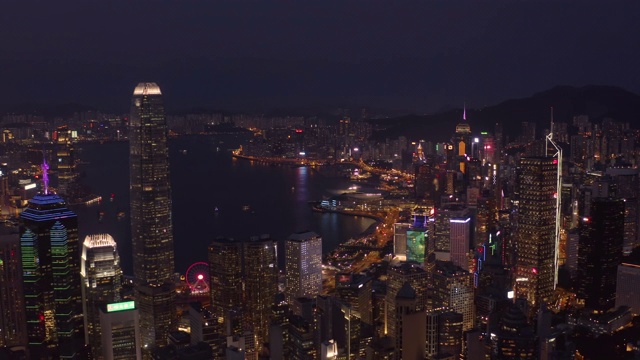 无人机夜间鸟瞰香港城市景观。紧密的空中向前射击飞过办公大楼和摩天大楼。视频素材