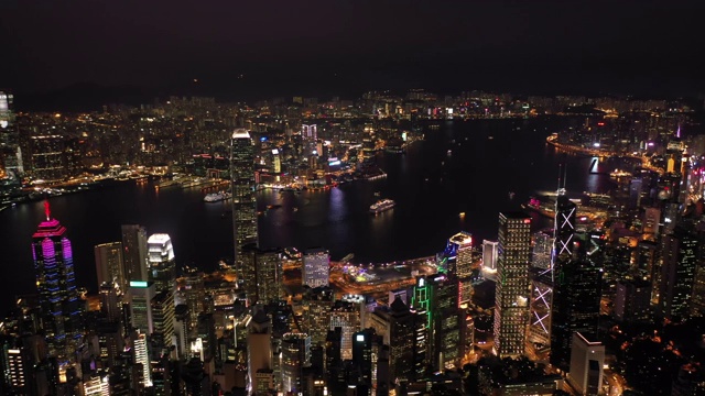 无人机夜间鸟瞰香港城市景观。紧密的空中向前射击飞过办公大楼和摩天大楼。视频素材