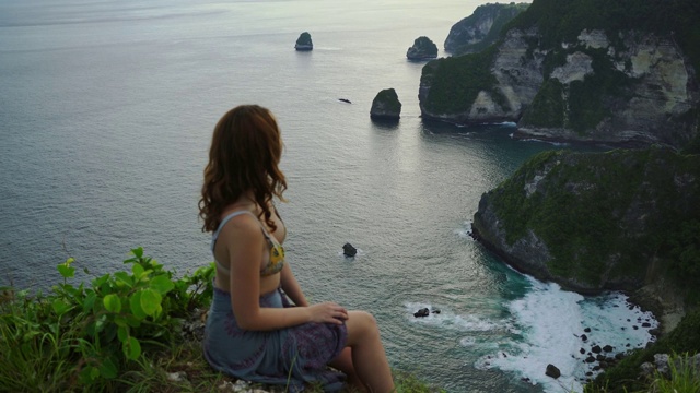 从努沙佩尼达悬崖上看海滩的女人的风景视频素材