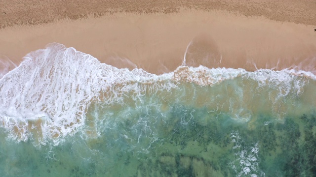 从空中俯瞰夏威夷考艾岛的原始海滩和冲浪视频素材