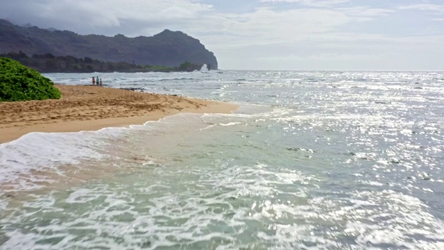 从空中俯瞰夏威夷考艾岛隐蔽的海滩和冲浪视频素材