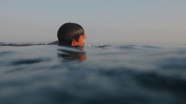 一个十几岁的男孩暑假在海里游泳视频素材