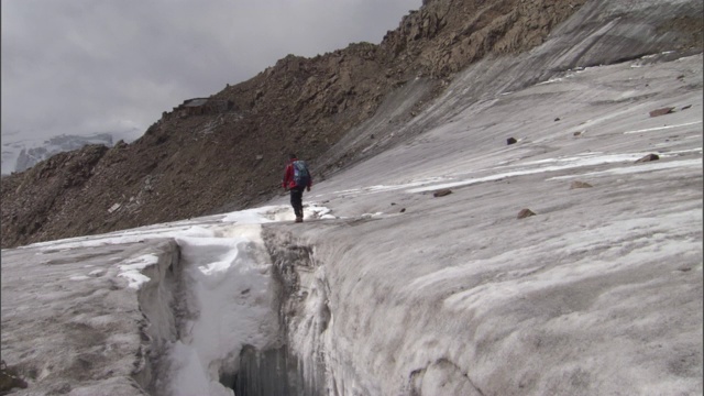 一个徒步旅行者穿过冰川走向维奥兹山。视频素材