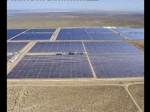 太阳能电池板阵列排列在沙漠道路上。视频素材