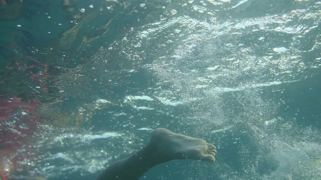 水下摄像机拍摄的女子在暑假期间在公海游泳视频素材