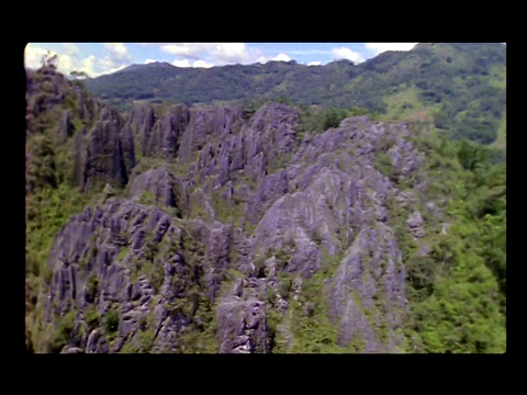 树木覆盖着岩石嶙峋的山景。视频素材