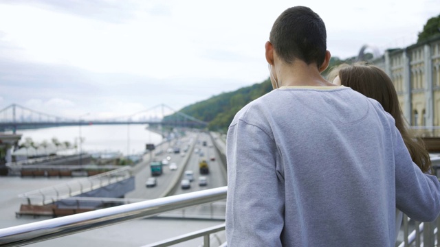 青年男女站在城市里欣赏着美丽的风景。视频素材