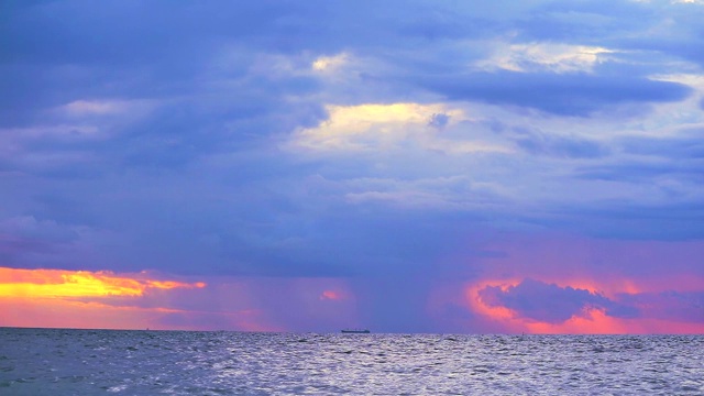 货船停泊在海上，紫色的夕阳和雨滴落回天空视频素材