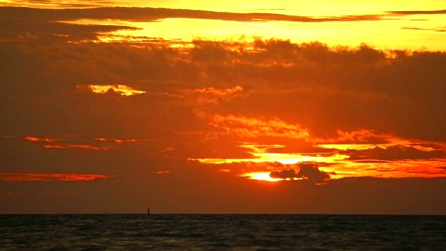 夕阳橘红色的天空和暗红色的云移动在海上时间流逝视频素材