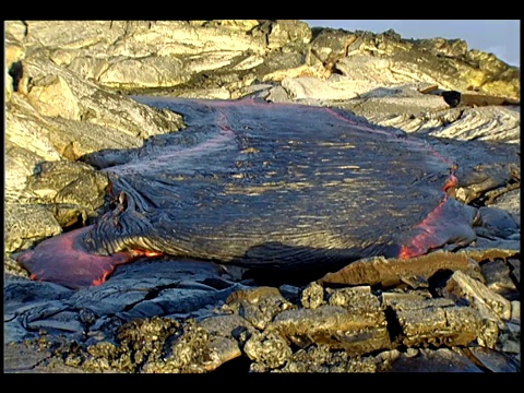 硬化的黑色熔岩从岩石火山流下。视频素材