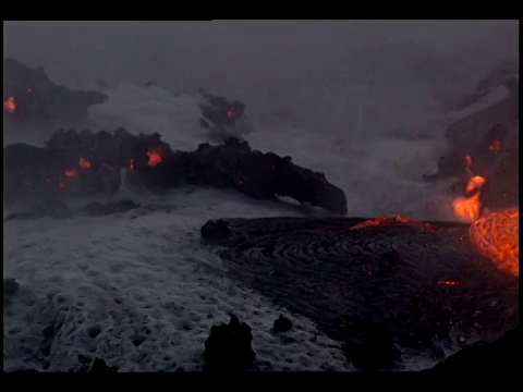 波浪溅到熔岩流上，热气形成沸腾的气泡。视频素材